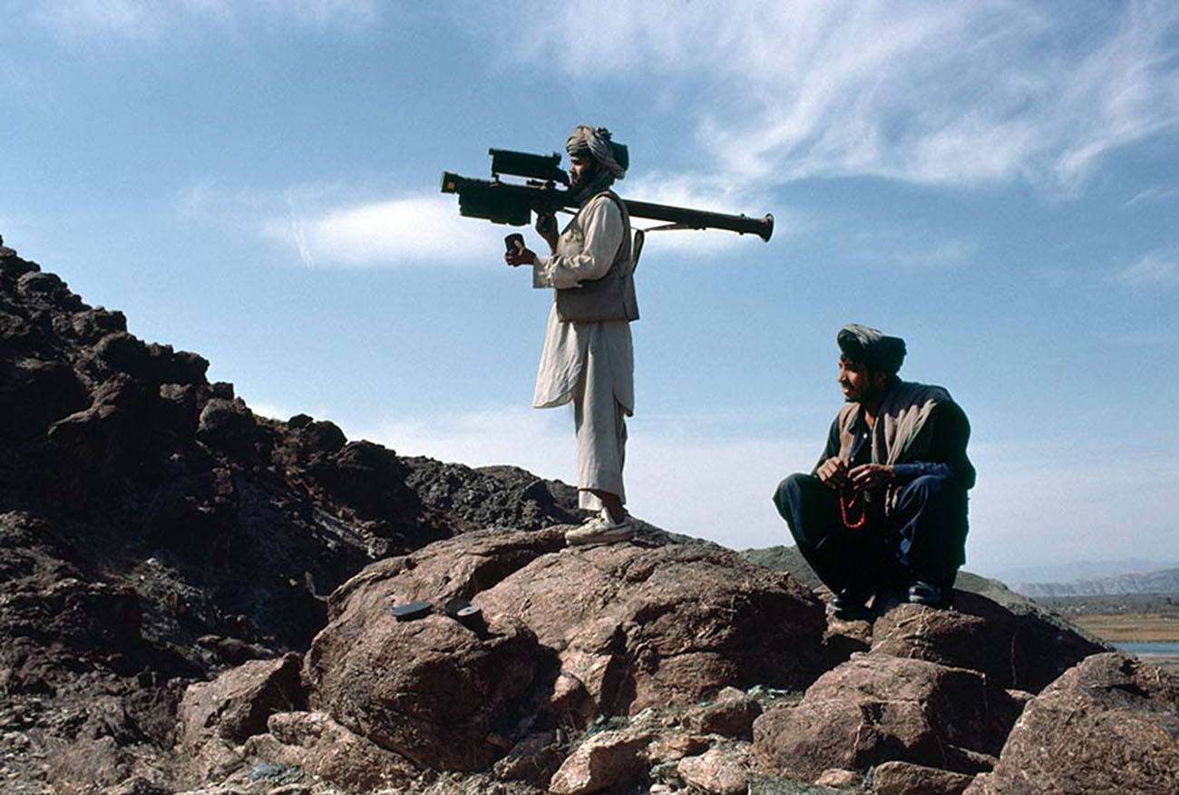 An Afghan mujahideen aims a FIM-92 Stinger missile at passing Soviet aircraft, 1988.